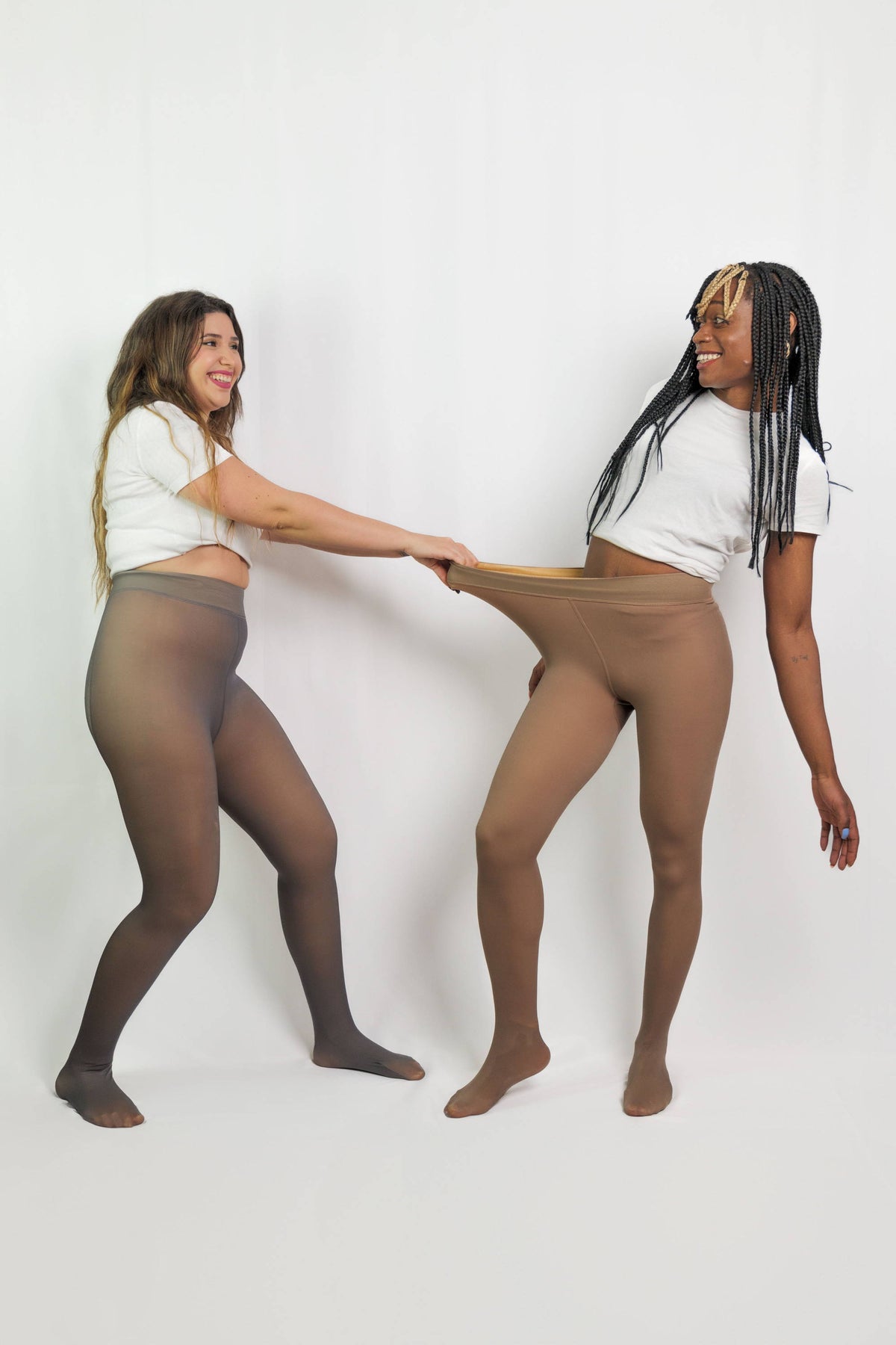 Femme portant un collant polaire Leggs, jupe noire et bottes, sur fond studio