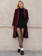 Collant fantaisie à petits nœuds porté avec manteau bordeaux – Leggs